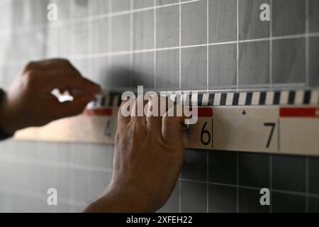 Neckartailfingen, Allemagne. 27 juin 2024. Un enseignant tient une règle jusqu'à un tableau noir dans une classe de quatrième année dans une école primaire et fait une note sur le tableau. Crédit : Marijan Murat/dpa - ATTENTION : pour usage éditorial uniquement et uniquement avec référence complète au crédit/dpa/Alamy Live News ci-dessus Banque D'Images