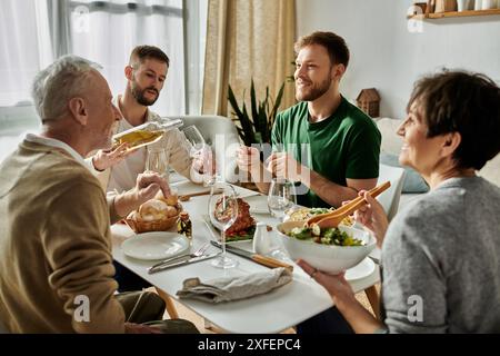 Un couple gay partage un repas avec les parents à la maison. Banque D'Images