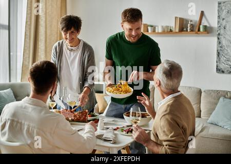 Un couple gay partage un repas avec les parents à la maison. Banque D'Images