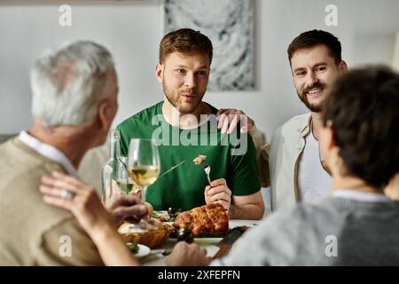 Un couple gay partage un repas avec les parents à la maison. Banque D'Images