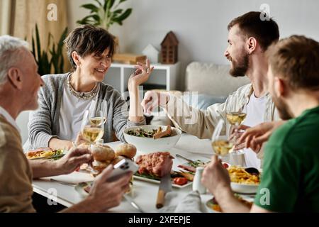 Un couple gay partage un repas avec les parents à la maison. Banque D'Images