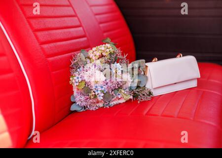 Symbolfoto : Bund der Ehe Brautstrauß und weiße Handtasche liegen im Brautauto auf einer roten Sitzbank Trauung Ehe Hochzeit Braut Braeutigam Standesamt Liebe Heiratszeremonie Bodenheim Rheinland-Pfalz Deutschland *** photo symbolique union mariage mariage bouquet de mariée et sac à main blanc couché dans la voiture des mariées sur un banc rouge mariage mariage mariage mariage mariage mariage mariage mariage registre Office Love Marriage Ceremony Bodenheim Rhénanie Palatinat Allemagne Copyright : xBEAUTIFULxSPORTS/Hahnex Banque D'Images