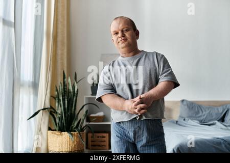 Un homme inclusif se tient dans sa maison, regardant vers la caméra. Banque D'Images