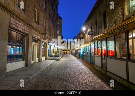 Restaurants et boutiques dans une rue pavée à l'intérieur des murs de la vieille ville de St Malo la nuit, llle-et-Vilaine, Bretagne, France Banque D'Images