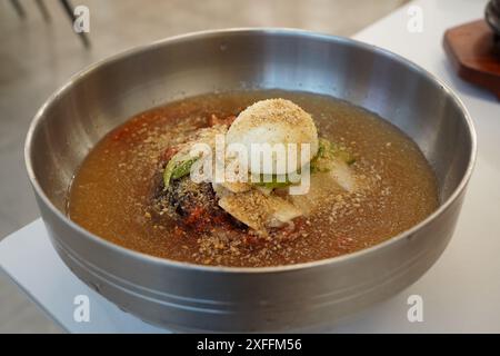 Le Naengmyeon est un plat de nouilles coréennes unique préparé avec un bouillon froid garni d'assaisonnements et de garnitures Banque D'Images