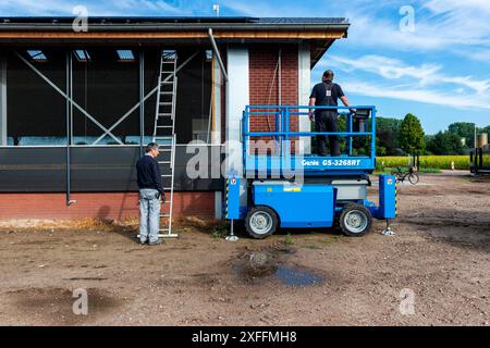 Installation de panneaux de cellules solaires deux artisans électriciens installent des panneaux de cellules solaires sur le toit d'une ferme agricole de viande de taureau. Les changements environnementaux et climatiques sont éminents et exigent un passage aux sources d'énergie renouvelables. Les agriculteurs voient une difficulté à gagner un flux de revenus supplémentaire. Goirle / Hilvarenbeek, pays-Bas. Goirle / Hilvarenbeek Boerderij de Walhoeve, Boterpad Noord-Brabant Nederand Copyright : xGuidoxKoppesxPhotox Banque D'Images