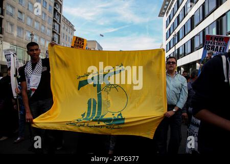 Londres, Royaume-Uni. 3 juin 2010. Londres, Royaume-Uni. 03 juin 2010. Un drapeau du Hezbollah est hissé lors d'une manifestation pro-palestinienne dans le centre de Londres le 3 juin 2010, au moment où le Royaume-Uni a reconnu l'appareil politique du Hezbollah comme un acteur non étatique légitime. Pourtant, en mars 2019, le Royaume-Uni a désigné le Hezbollah dans son intégralité (pas seulement son aile militaire, mais aussi son appareil politique) comme une organisation terroriste, et soutenir le Hezbollah est devenu un délit. Le Hezbollah, qui signifie ''Parti de Dieu'' en arabe, est un parti politique islamique chiite et un groupe militant basé au Liban (Credit Banque D'Images