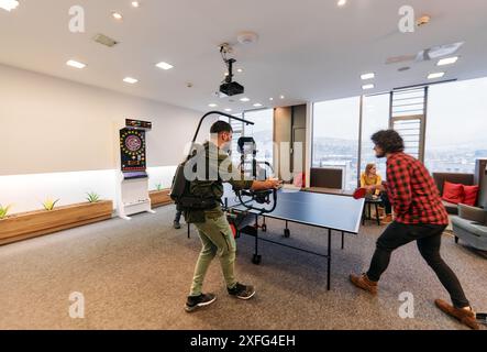 Le vidéaste capture des collègues d'affaires jouant au tennis de table pendant la pause Banque D'Images