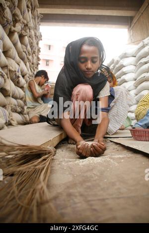 Les enfants ramassent les restes de riz au marché de gros de Badamtoli dimanche, incapables de se payer les produits essentiels à cause de la flambée des prix. 06 avril 2008 Banque D'Images