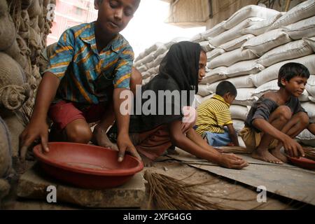 Les enfants ramassent les restes de riz au marché de gros de Badamtoli dimanche, incapables de se payer les produits essentiels à cause de la flambée des prix. 06 avril 2008 Banque D'Images