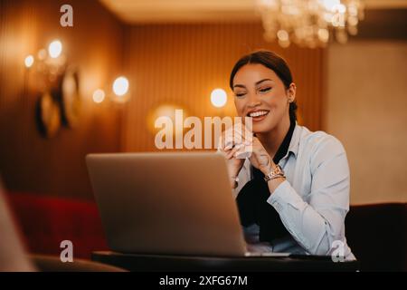 Radiant Latina femme d'affaires dirige avec confiance la réunion d'affaires autour d'un café. Banque D'Images