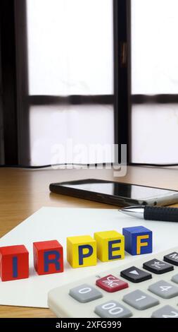 Écrit IRPEF en italien (impôt sur le revenu des particuliers), un seul mot écrit sur des cubes en bois, sur un bureau avec fenêtre. Banque D'Images