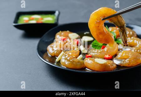 Crevettes marinées avec baguettes sauce soja, piment et ail sur fond de pierre, nourriture coréenne Banque D'Images