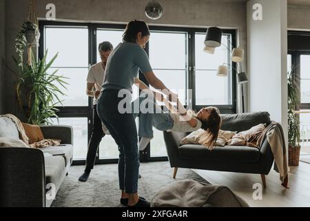 Mère jouant avec sa fille dans le salon à la maison Banque D'Images