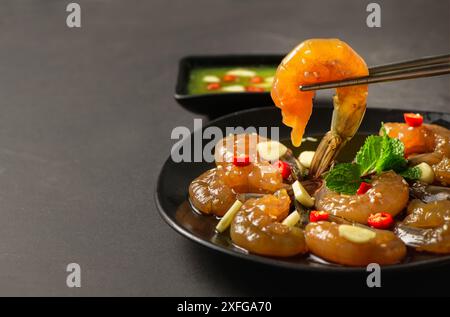 Crevettes marinées avec baguettes sauce soja, piment et ail sur fond de pierre, nourriture coréenne Banque D'Images