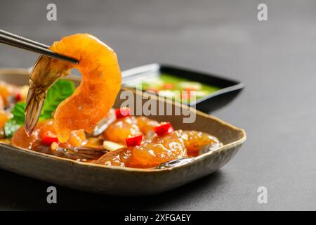 Crevettes marinées avec baguettes sauce soja, piment et ail sur fond de pierre, nourriture coréenne Banque D'Images