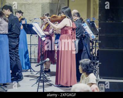 Cremona, Italie - 28 juin 2024 Cremona Summer Festival ensemble Miyaji, musiciens en robes élégantes et costumes jouant des violons sur scène pendant un c. Banque D'Images