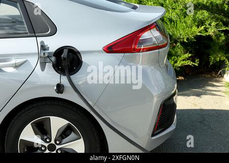 Recharge de voiture électrique moderne depuis la station à l'extérieur Banque D'Images