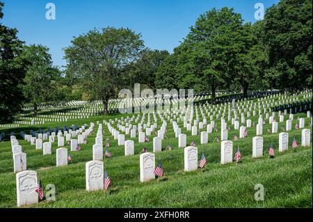 Une vue solennelle du cimetière national d'Arlington avec des rangées de pierres tombales blanches et des drapeaux américains par une journée ensoleillée Banque D'Images