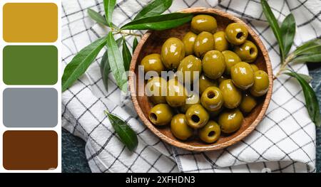 Bol de délicieuses olives vertes sur table, vue de dessus. Différents motifs de couleur Banque D'Images