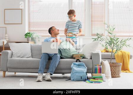 Père et son petit fils avec la boîte à lunch de l'école emballage sac à dos à la maison Banque D'Images