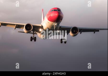 Un gros avion de passagers s'approche de la piste avec le train d'atterrissage abaissé Banque D'Images