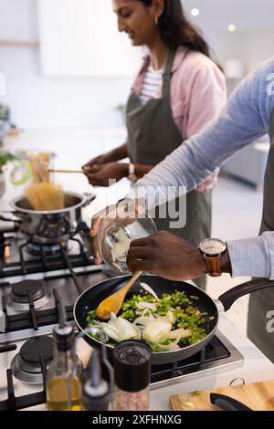 Cuisiner ensemble, couple préparant le repas avec des légumes frais dans une cuisine moderne Banque D'Images