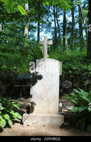 Une tombe avec une croix dans un cimetière à Eglaine, Lettonie Banque D'Images