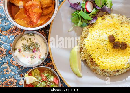 Magnifique vue de dessus des plats traditionnels iraniens et des collations. Polow, kufte, salade de légumes frais et yaourt. Cuisine persane impressionnante. Banque D'Images