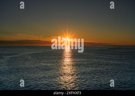 Un lever de soleil doré vibrant sur la mer du Nord du Skagerrak, avec les rayons du soleil se reflétant sur l'eau, près des côtes norvégienne et suédoise Banque D'Images