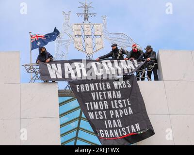 04 juillet 2024, Australie, Canberra, Parlement. Un manifestant pro-palestinien monte sur le toit du Parlement australien pour déployer des banderoles critiquant le rôle du gouvernement australien dans la facilitation du génocide à Gaza Banque D'Images