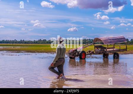 Un fermier cambodgien passe devant son tracteur. Réservoir West Baray, parc archéologique d'Angkor, province de Siem Reap, Cambodge, Indochine. © Kraig Lieb Banque D'Images