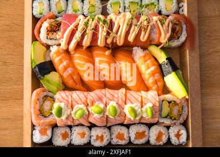 Sushi assorti avec nigiri, rouleaux et ingrédients frais dans une boîte en carton pour la livraison Banque D'Images