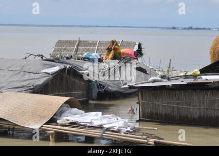 Morigaon. 3 juillet 2024. Les villageois se réfugient au sommet de leur hutte partiellement submergée dans une zone touchée par les inondations dans le district de Morigaon, dans l'État d'Assam, au nord-est de l'Inde, le 3 juillet 2024. Crédit : Str/Xinhua/Alamy Live News Banque D'Images