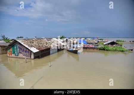 Morigaon. 3 juillet 2024. Les villageois rament un bateau près d'une maison submergée dans la zone touchée par les inondations dans le district de Morigaon, dans l'État indien d'Assam, au nord-est du pays, le 3 juillet 2024. Crédit : Str/Xinhua/Alamy Live News Banque D'Images