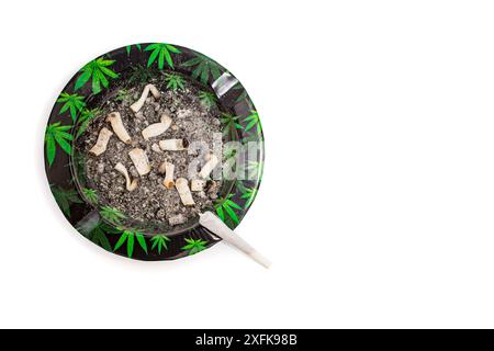 Cigarette commune de marijuana sur un cendrier sale avec motif de feuilles de cannabis, plat isolé Banque D'Images