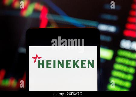 23 juin 2024, Chine : dans cette illustration photo, le logo de la multinationale brassicole néerlandaise Heineken N.V. est affiché sur un smartphone avec un graphique de l'indice boursier économique en arrière-plan. (Crédit image : © Budrul Chukrut/SOPA images via ZUMA Press Wire) USAGE ÉDITORIAL SEULEMENT! Non destiné à UN USAGE commercial ! Banque D'Images