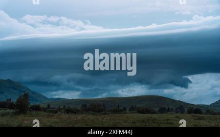 De sombres nuages de pluie pendent au-dessus des montagnes Banque D'Images