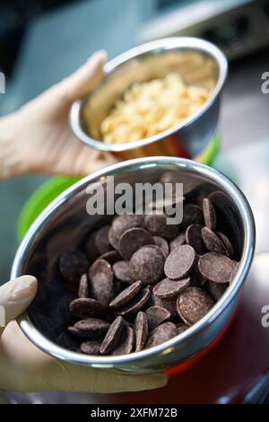 Vue rapprochée des pépites de chocolat noir et laiteux dans des bols en fer Banque D'Images