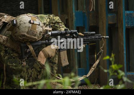 Jeu Airsoft dans la rue près de bâtiments abandonnés, un homme dans un uniforme américain vise une arme Airsoft Banque D'Images