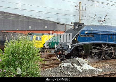 60007 'Sir Nigel Gresley' en direction d'un tour de chemin de fer à la gare de Preston, avec Freightliner 70009 descendant Preston Docks Line en arrière-plan. Banque D'Images