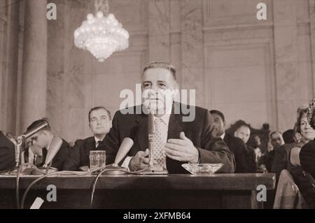 Photo vintage du mafioso Joseph 'Joe Cago' Valachi de la famille du crime Genovese, témoignant sur le crime organisé et la mafia lors d'une audition de la sous-Commission permanente sur les enquêtes de la Commission sénatoriale sur la sécurité intérieure et les affaires gouvernementales (Commission McClellan), comme l'homme pointe à la carte des organisations de la mafia. USA, 1 octobre 1963 par W.K. Leffler Banque D'Images