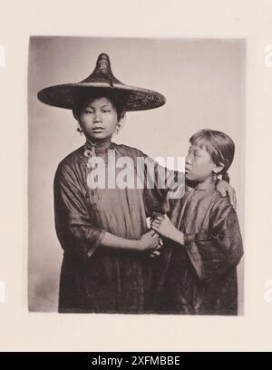 Photo vintage de Canton Boat-girls en robe chinoise traditionnelle. Illustrations de la Chine du XIXe siècle, 1875. Ce sont les deux filles d'une famille respectable de plaisanciers. Ils ont été traités à l'utilisation de l'aviron, et à la gestion des bateaux, dès la plus tendre enfance. Heureux pour eux, ils ne sont pas des esclaves, achetés par une dame dessinatrice, et destinés à un sort pire que la vie de l'industrie prudente commune aux travailleurs pauvres de Canton. Les filles, habillées avec une simplicité modeste, pondent leurs cheveux noirs brillants avec une fleur de couleur vive qui rehausse l'effet de leurs yeux sombres Banque D'Images