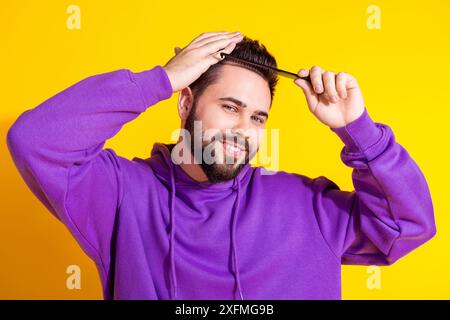 Photo de beau bel homme agréable attrayant porter des cheveux de brosse de vêtements à la mode pourpre isolés sur fond de couleur jaune Banque D'Images