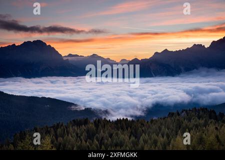 Aube au-dessus du Monte Cristallo et de Cortina d'Ampezzo depuis Cinque Torri, avec nuages bas, Dolomites, province de Belluno, Vénétie, Italie, septembre 2015. Banque D'Images