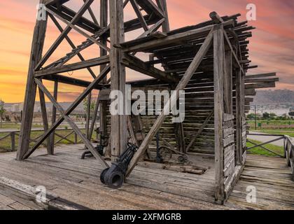 Vue rapprochée du premier puits de pétrole foré industriellement à Bakou, Azerbaïdjan. La structure en bois du puits est visible, ainsi qu'un aperçu de l'horizon de la ville en arrière-plan Banque D'Images