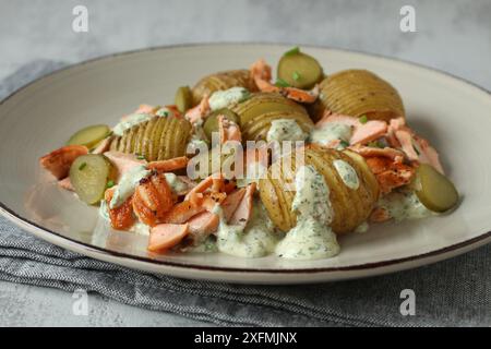 Salade de pommes de terre Hasselback avec cornichons et truite saumon Banque D'Images