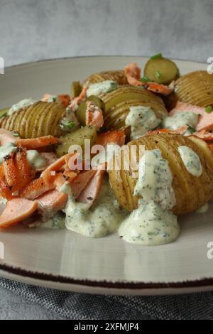 Salade de pommes de terre Hasselback avec cornichons et truite saumon Banque D'Images
