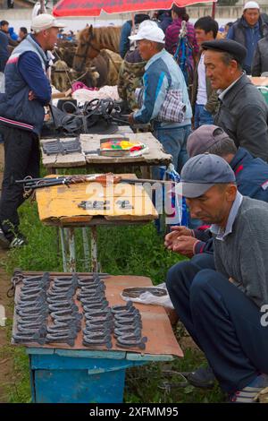 Hommes vendant des chaussures de cheval au marché aux animaux de Karakol. Kirghizistan, juillet 2016. Banque D'Images