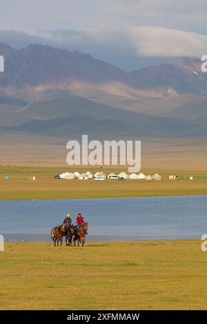 Les cavaliers et les yourtes par chanson Kul Lake, au Kirghizistan. Août 2016. Banque D'Images
